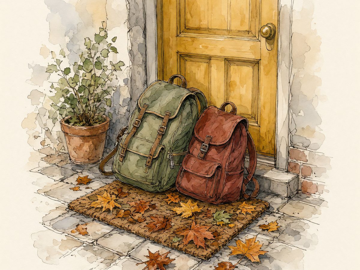 A large and a small backpack propped by a front door